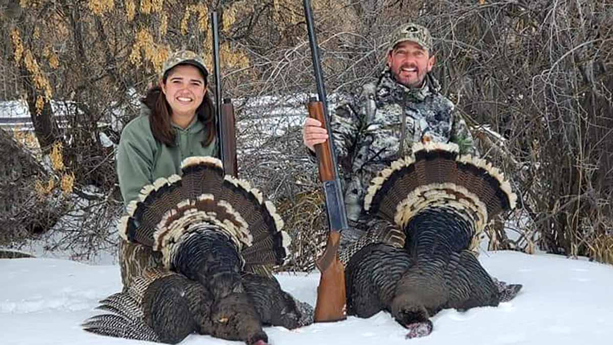 Angie Wonnacott and her husband Bret posing with wild turkeys that they harvested