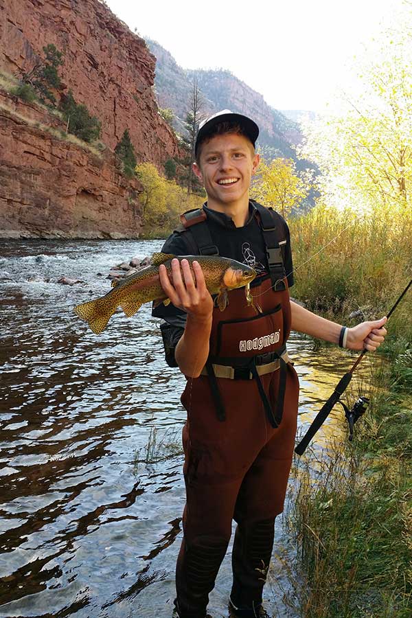 Braden Cook holding a rainbow trout