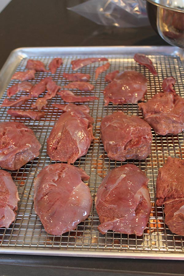 Pieces of raw, unprocessed goose meat laid down on a tray