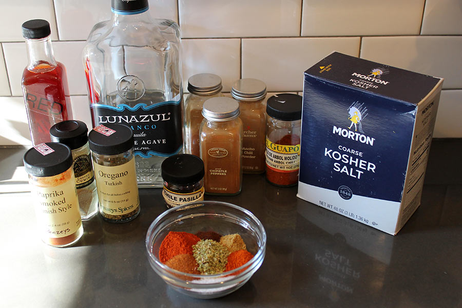 Arrangement of ingredients for the chorizo mixture, including ground paprika, cumin, oregano, chile powder, vinegar, tequila and salt