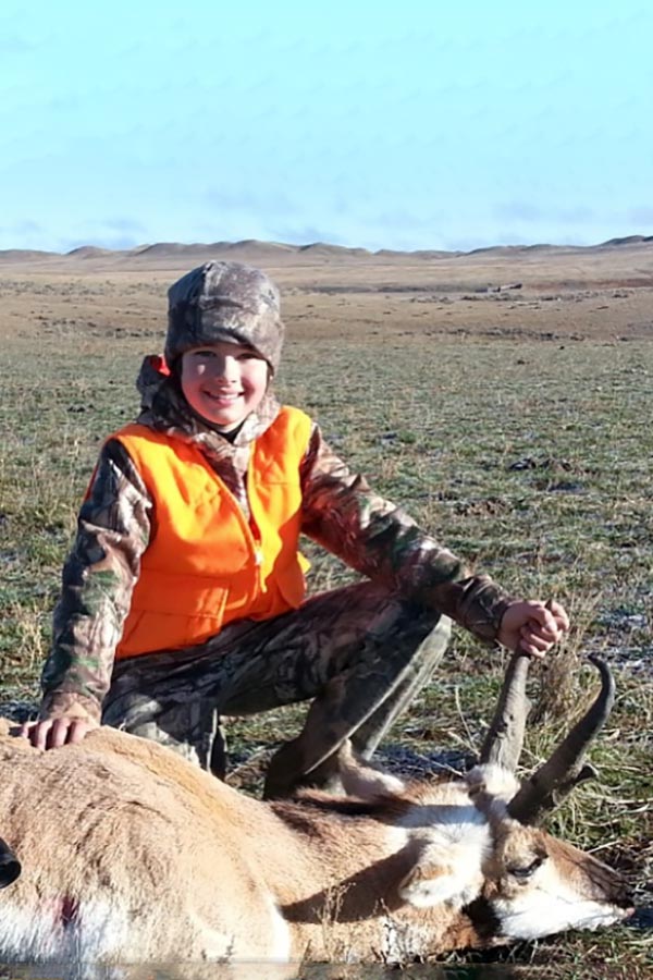 The author's son with a harvested pronghorn in a field