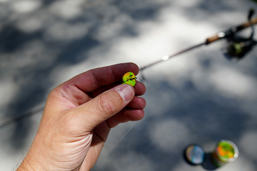 Una pieza de PowerBait del tamaño de una canica moldeada en un anzuelo triple en una línea de pesca