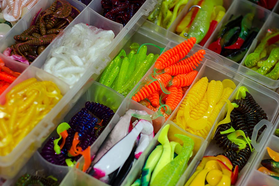 Varios cebos de pescado blandos multicolores en una caja