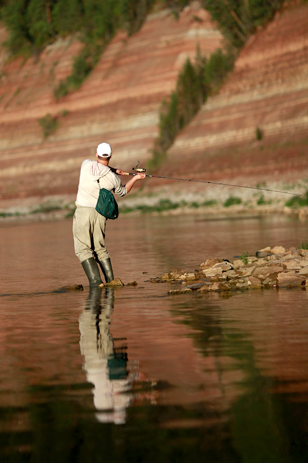 Hombre lanzando un hilo de pescar al agua