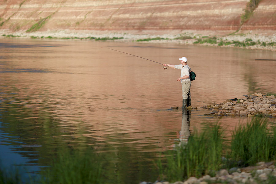 Hombre sujetando un hilo de pescar en el agua