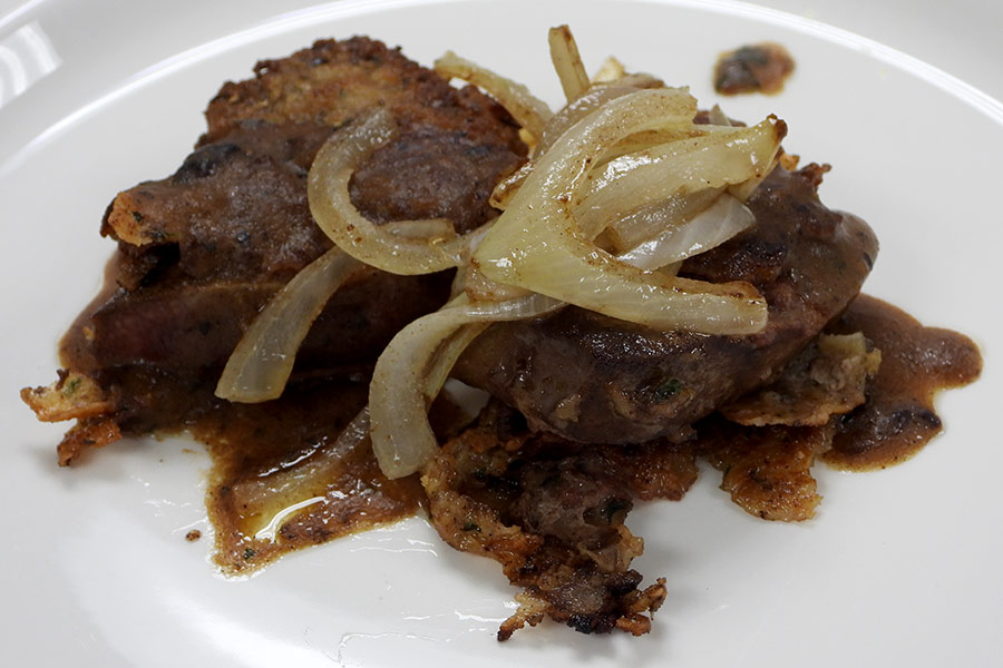 Pan-fried elk liver sprinkled with onions on a plate
