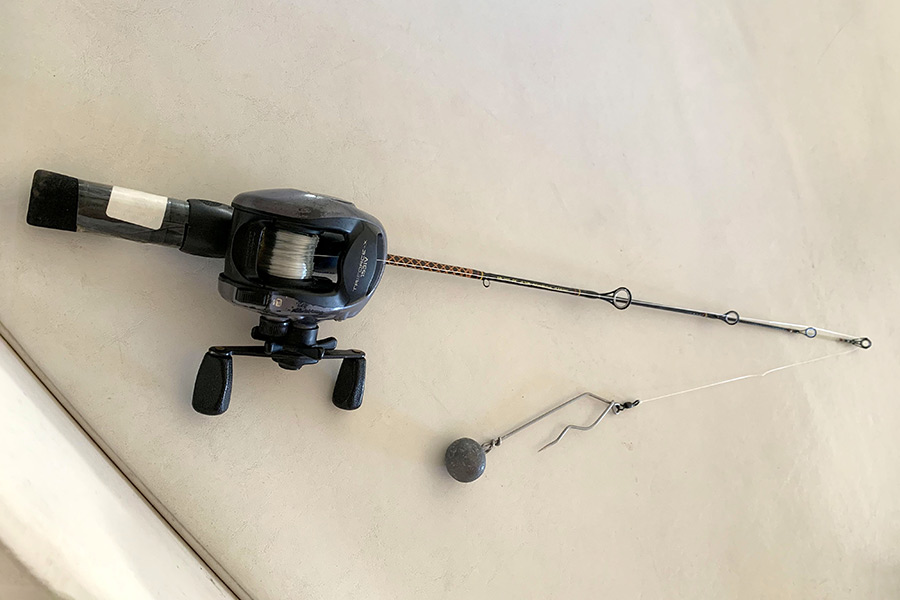 An ice fishing pole with a weighted descender rig attached to the line
