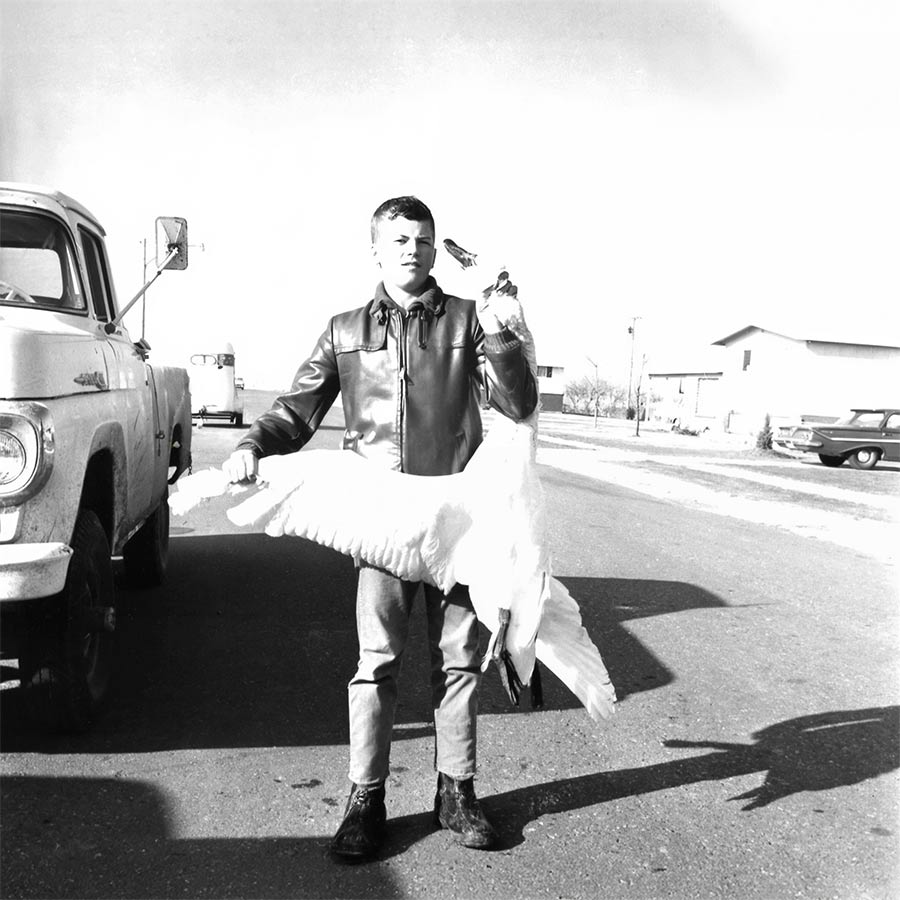 Young hunter holding a swan harvested from Ogden Bay
