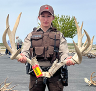 Utah DWR conservation office posing in front of a truck with shed antlers