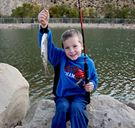 Niño sosteniendo un pez capturado en el Gigliotti Pond