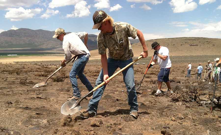 Volunteer dedicated hunters shoveling dirt, working on a service project
