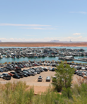 Marina at Lake Powell, with dozens of cars parked and boats docked