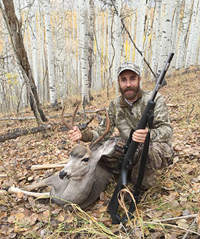 Hunter with a rifle and a harvested buck deer