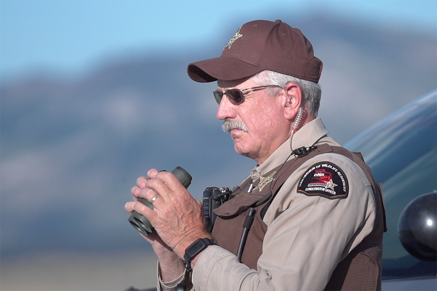 Utah DWR conservation officer holding a scope