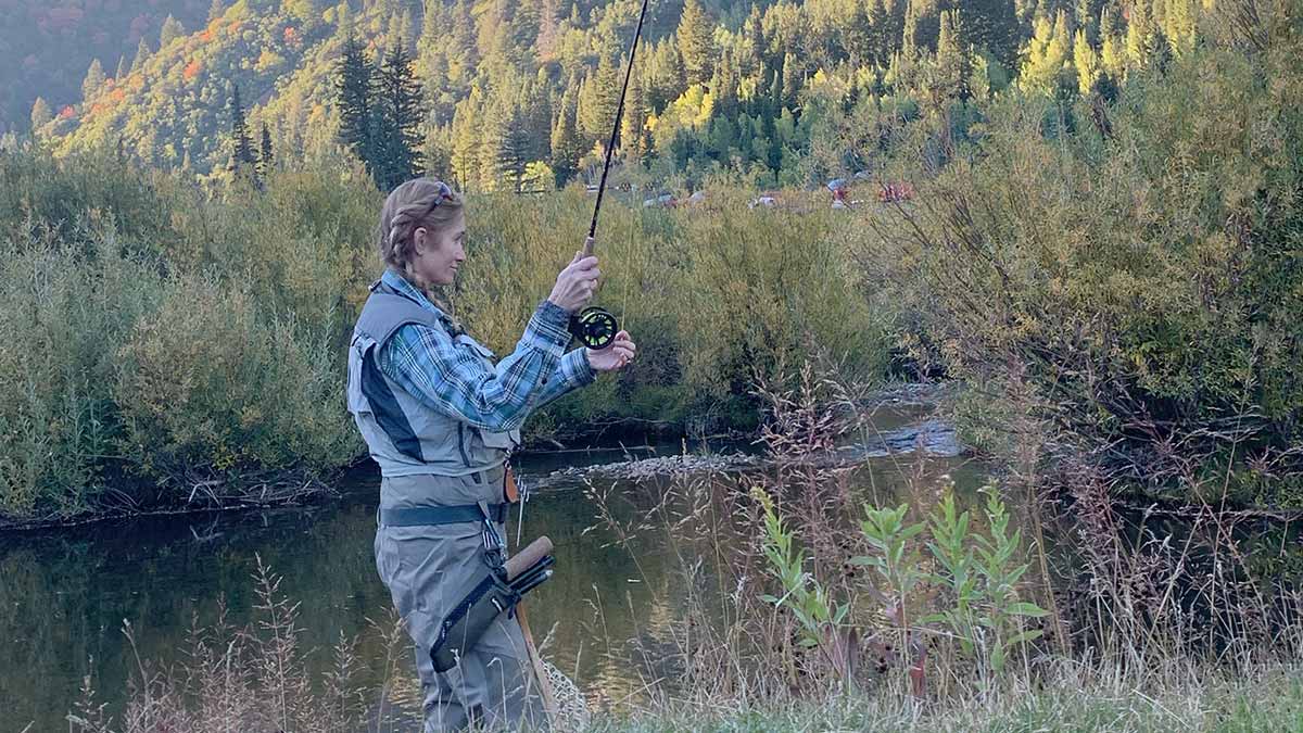 Sarah Wiser casting a fishing line in a river