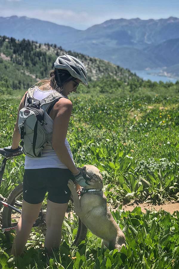 Hiking biker and dog on a lush mountain trail