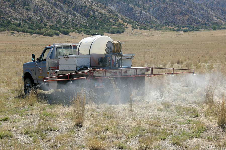 Truck spraying a field near Levan