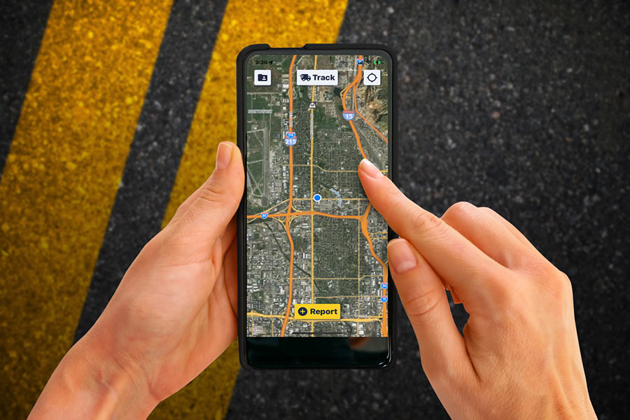 Hand holding a phone with the Roadkill Reporter app