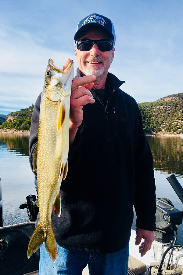 Angler holding lake trout "pup," caught at Flaming Gorge