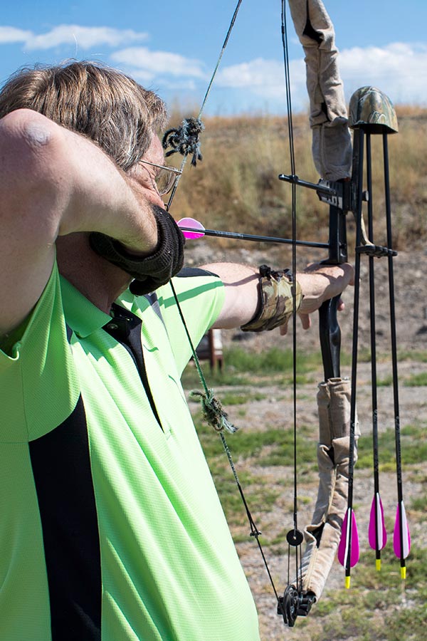 Man shooting a arrow at an archery range at Lee Kay