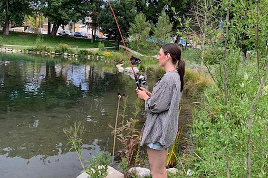 Woman casting a fishing line at Fairmont Park Pond, a community fishery