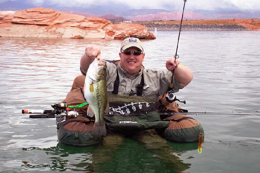 Angler holding a caught largemouth bass fish at Sand Hollow Reservoir